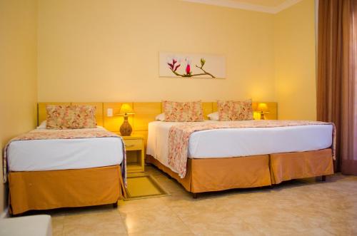 1 dormitorio con 2 camas y mesa con lámpara en Grande Hotel Glória, en Águas de Lindóia