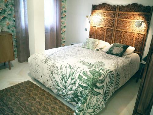 a bedroom with a large bed with a wooden headboard at Apartamento Casa Palabra in Santander