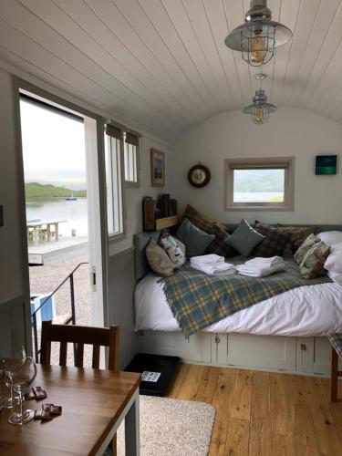 a bedroom with a bed with a view of the ocean at Fisherman's Hut in Tarbert
