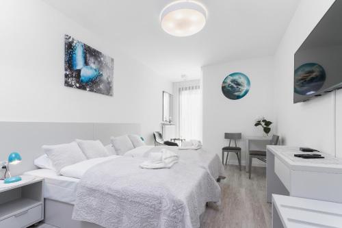 a white room with a bed and a couch at Apartments Kraków Rajska 3 by Renters in Krakow