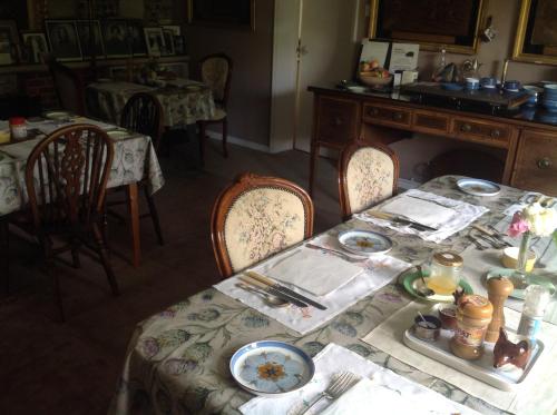 a dining room with a table with plates of food at The Mill House in Berwick Saint James
