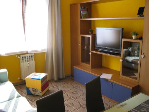 een woonkamer met een tv op een stand met een televisie bij au montfleury in Aosta