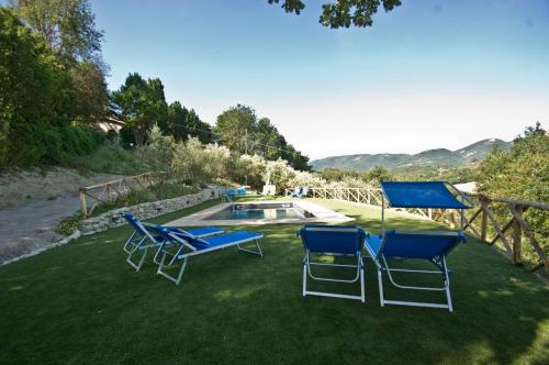 a group of chairs and an umbrella and a pool at Casale del Monsignore in Spoleto