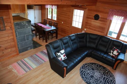 un soggiorno con un divano in pelle e un tavolo di Martinmäki a Virrat