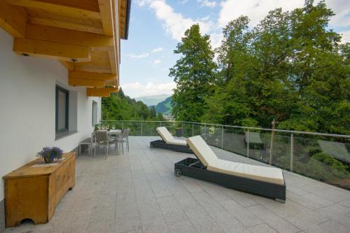 Un patio con sillas y una mesa en el balcón. en Apartment Sonnbichl, en Schwendau