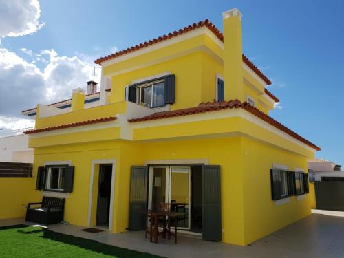a yellow house with a table in front of it at Holidays Home Comporta in Comporta