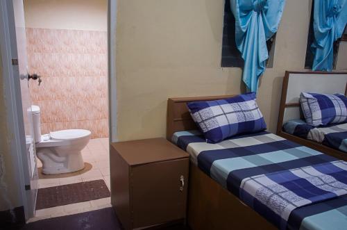 a small room with two beds and a toilet at RedDoorz @ Calceta Street Cogon in Tagbilaran City