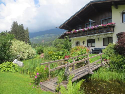 a house with a wooden bridge in a garden at Gästehaus Scharler in Neukirchen am Großvenediger