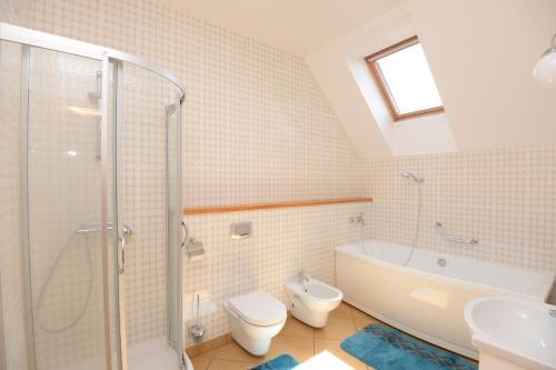 a bathroom with a shower and a toilet and a sink at Naujoji Karkle in Karklė