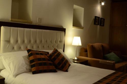 a bedroom with a bed with two pillows and a couch at To Kastri in Kalopanayiotis