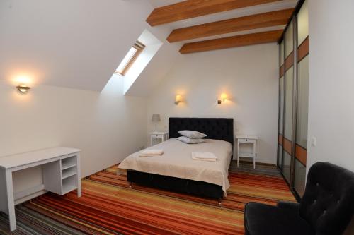 a bedroom with a bed and a desk and a chair at Naujoji Karkle in Karklė