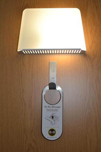 a light with a tag attached to a lightswitch at B&B HOTEL Grenoble Centre Alpexpo in Grenoble