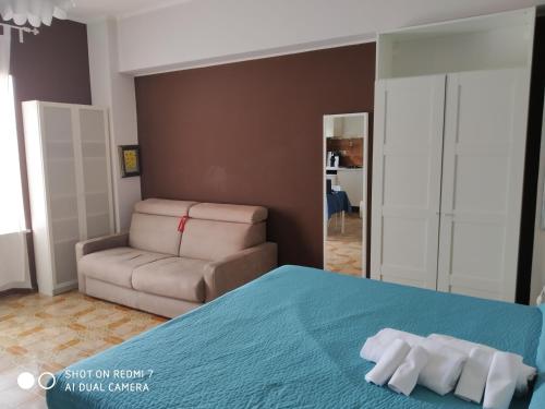 a bedroom with a bed with a couch and a chair at B&B Residenza Leonardo in Falconara Marittima