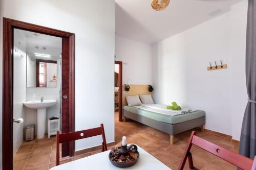 ブエナビスタ・デル・ノルテにあるTabaiba Guesthouseのリビングルーム(ベッド1台付)、バスルームが備わります。