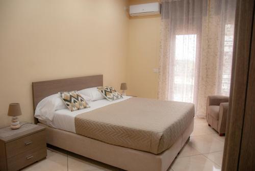 a bedroom with a bed and a chair and a window at Sorrento Comfort House con piscina in Sorrento