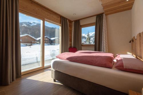 a bedroom with a bed and a large window at Chalet Cuna Bela in Livigno