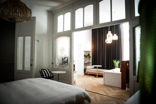 a room with a bed, a chair, and a window at Fitz Roy Urban Hotel, Bar and Garden in Maastricht
