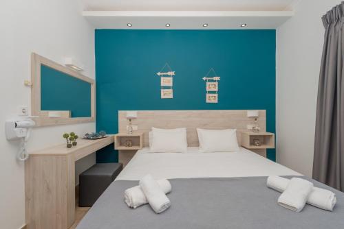 - une chambre avec un grand lit et un mur bleu dans l'établissement Stathis Studios I, à Laganas
