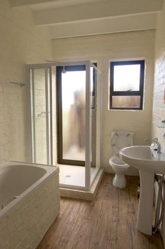 a bathroom with a tub and a toilet and a sink at Phillipskop Mountain Reserve in Stanford