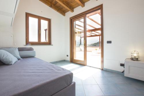 a bedroom with a bed and a sliding glass door at Venere Paolina - Goelba in Marciana