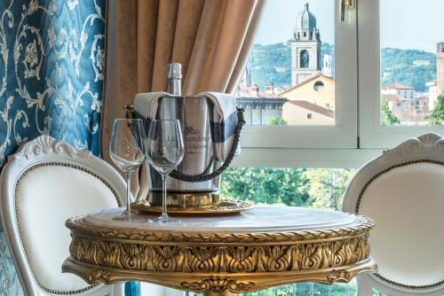 a table with two wine glasses and a window at Royal Olympus Verona in Verona