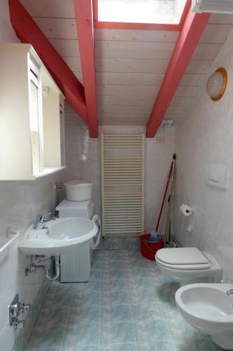 a bathroom with two sinks and a toilet and a window at Villetta Enrosadira in Vigo di Fassa