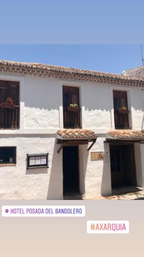 a white building with windows and a balcony at Hotel Posada del Bandolero in Borge