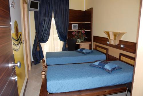 a bedroom with two beds and a window at Hotel Miramare in Porto Cesareo