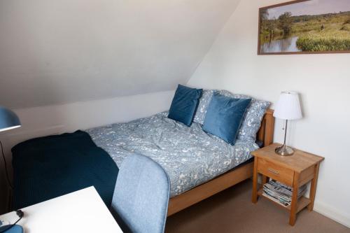 a small bedroom with a bed with blue pillows at Like home Bed & Breakfast in Varde