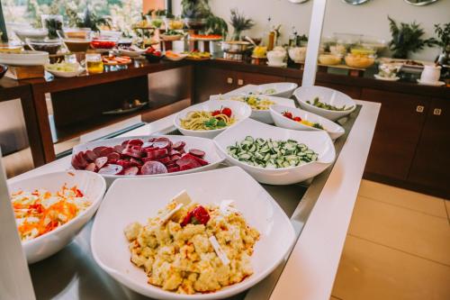 a buffet with many bowls of food on a table at Hotel Giannoulis in Paralia Katerinis