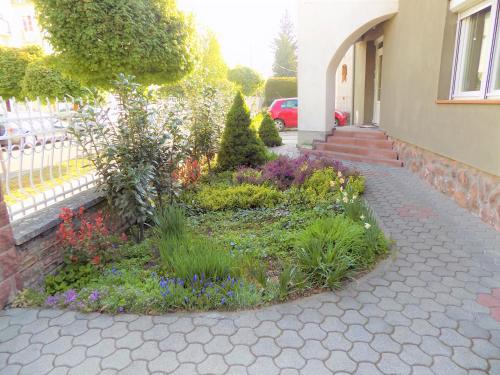 a garden in front of a house with flowers at Éva Vendégház in Kaposvár