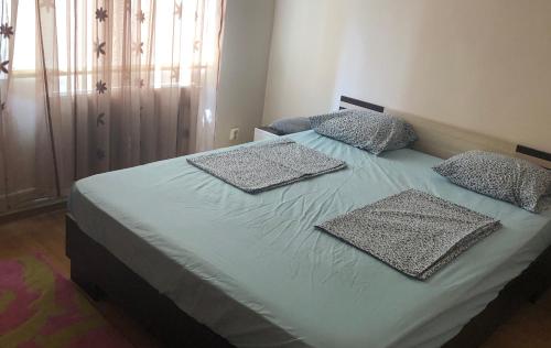 a bed with two pillows on it in a bedroom at MAMAIA FALEZA NORD in Constanţa