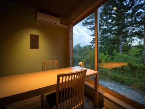 a dining room with a table and a large window at Nagisatei Taroan in Miyako