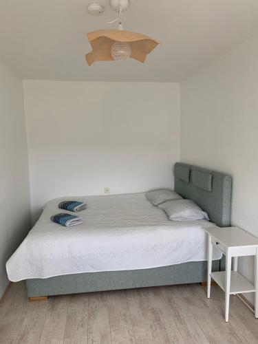 a bed with a green headboard and a table at Niine Apartment in Haapsalu