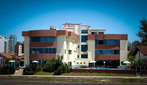 a building with a sign on top of it at De Rose Praia Hotel in Torres