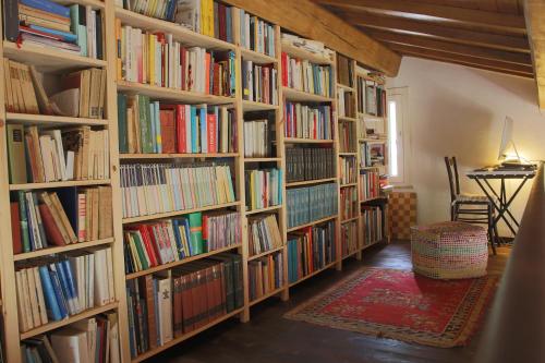 una fila de estanterías en una habitación llena de libros en B&B dell'Osteria en SantʼAnatolia di Narco