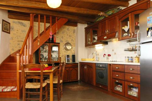 kuchnia z drewnianymi szafkami, stołem i schodami w obiekcie Vgorada w mieście Patsós