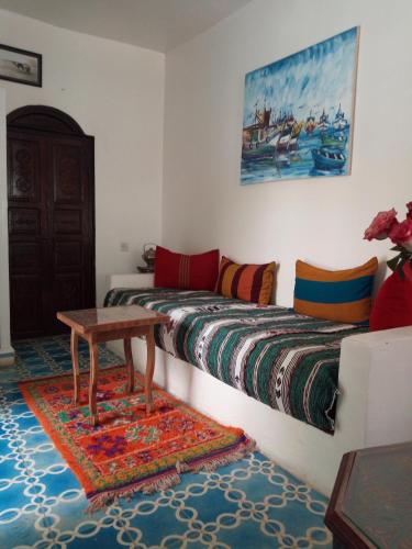a living room with two beds and a table at Riad Etoile De Mogador in Essaouira
