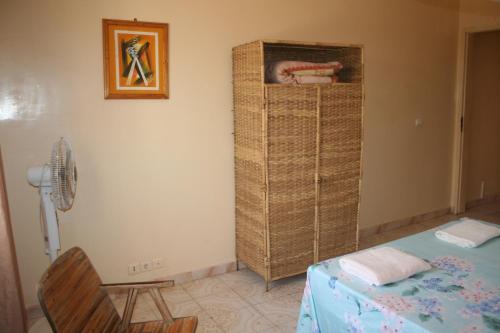 a bedroom with a bed and a fan next to a wall at Auberge Keur Diame in Dakar