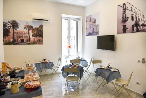 Pokój ze stołami i krzesłami oraz telewizorem z płaskim ekranem w obiekcie Ville Vesuviane w mieście San Giorgio a Cremano