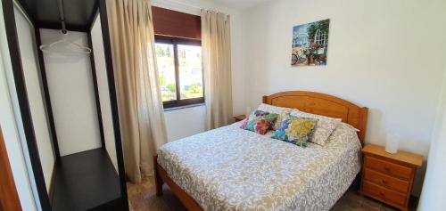 un dormitorio con una cama y una ventana en Keep Calm Apartments, en Ferragudo