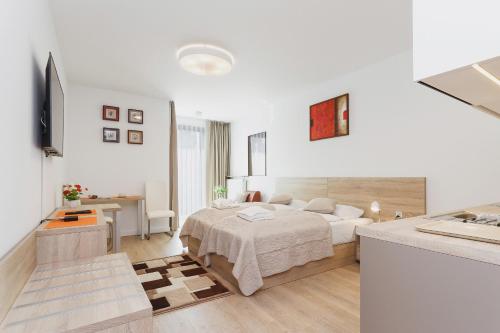 a white bedroom with a bed and a desk at Apartments Kraków Rajska 3 by Renters in Krakow