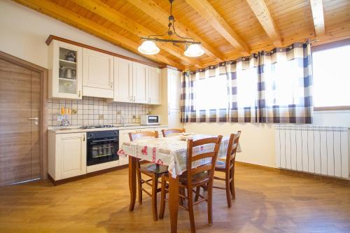 a kitchen with a table and chairs in a room at Etna Royal View in Trecastagni