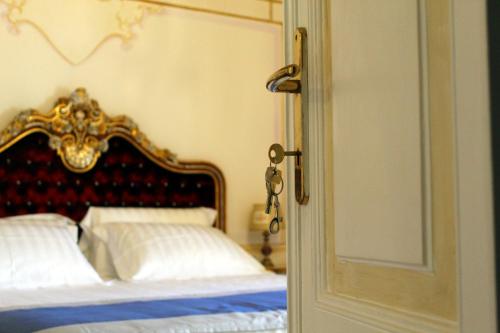 a bedroom with a bed with a red and gold headboard at Les Suite Royales in Sassari