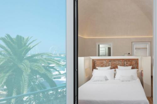 een slaapkamer met een bed en een palmboom bij Dimore Marinare in Trani