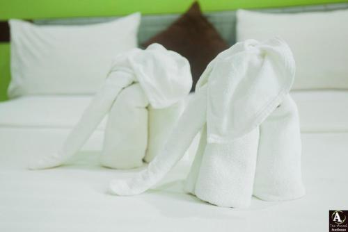two white towels sitting on top of a bed at The Areaac in Ban Chomphu