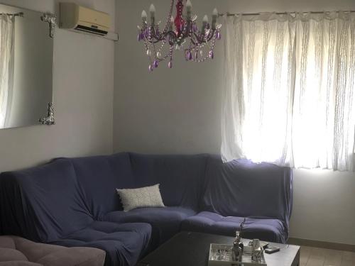 a blue couch in a living room with a chandelier at Casa di Lavanda in Hvar