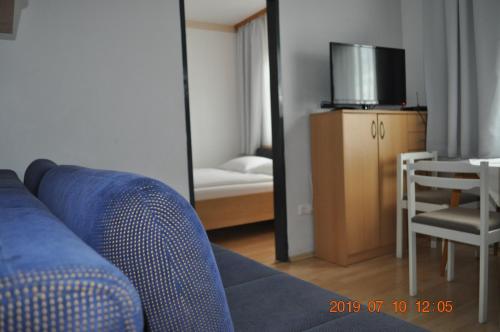 salon z niebieską kanapą i lustrem w obiekcie Appartmenthaus Josefikeller w mieście Podersdorf am See