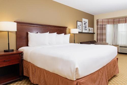 a large white bed in a hotel room at Country Inn & Suites by Radisson, Milwaukee West Brookfield , WI in Brookfield
