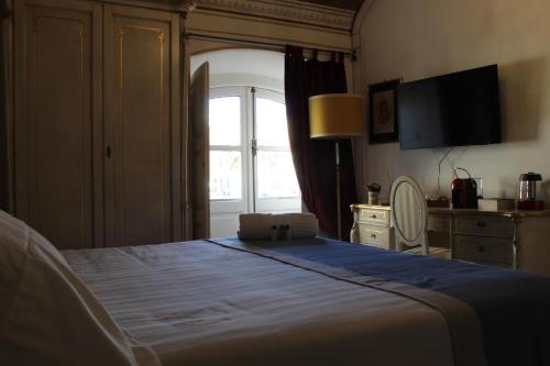 a bedroom with a large bed and a window at Les Suite Royales in Sassari